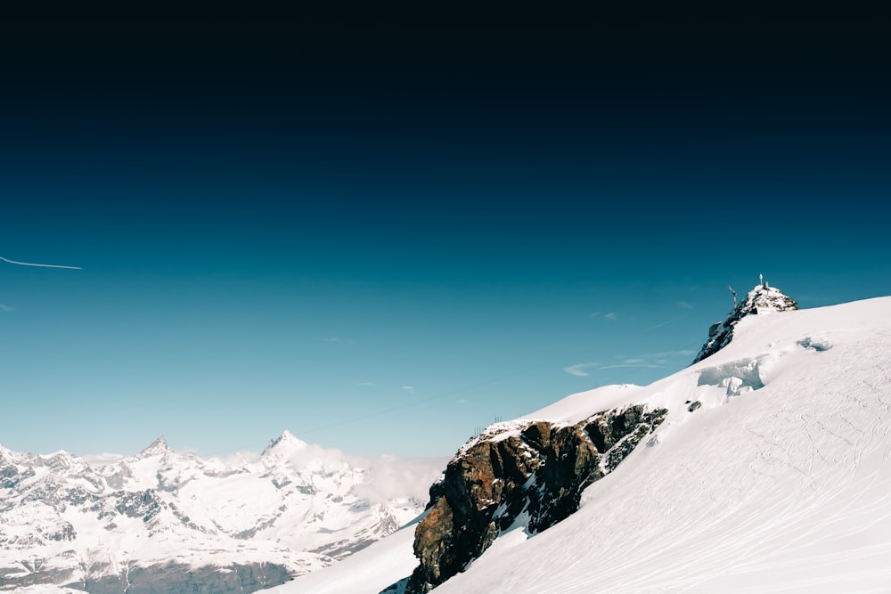 snow covered rock under blue sky