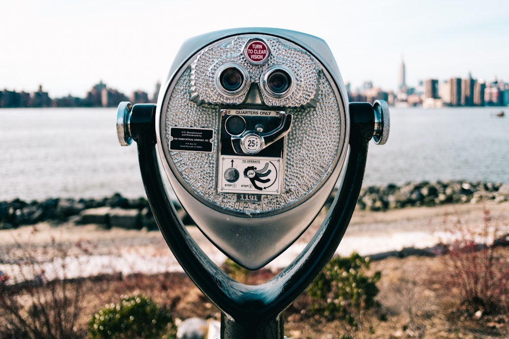 gray and black coin operated binoculars pointing to city