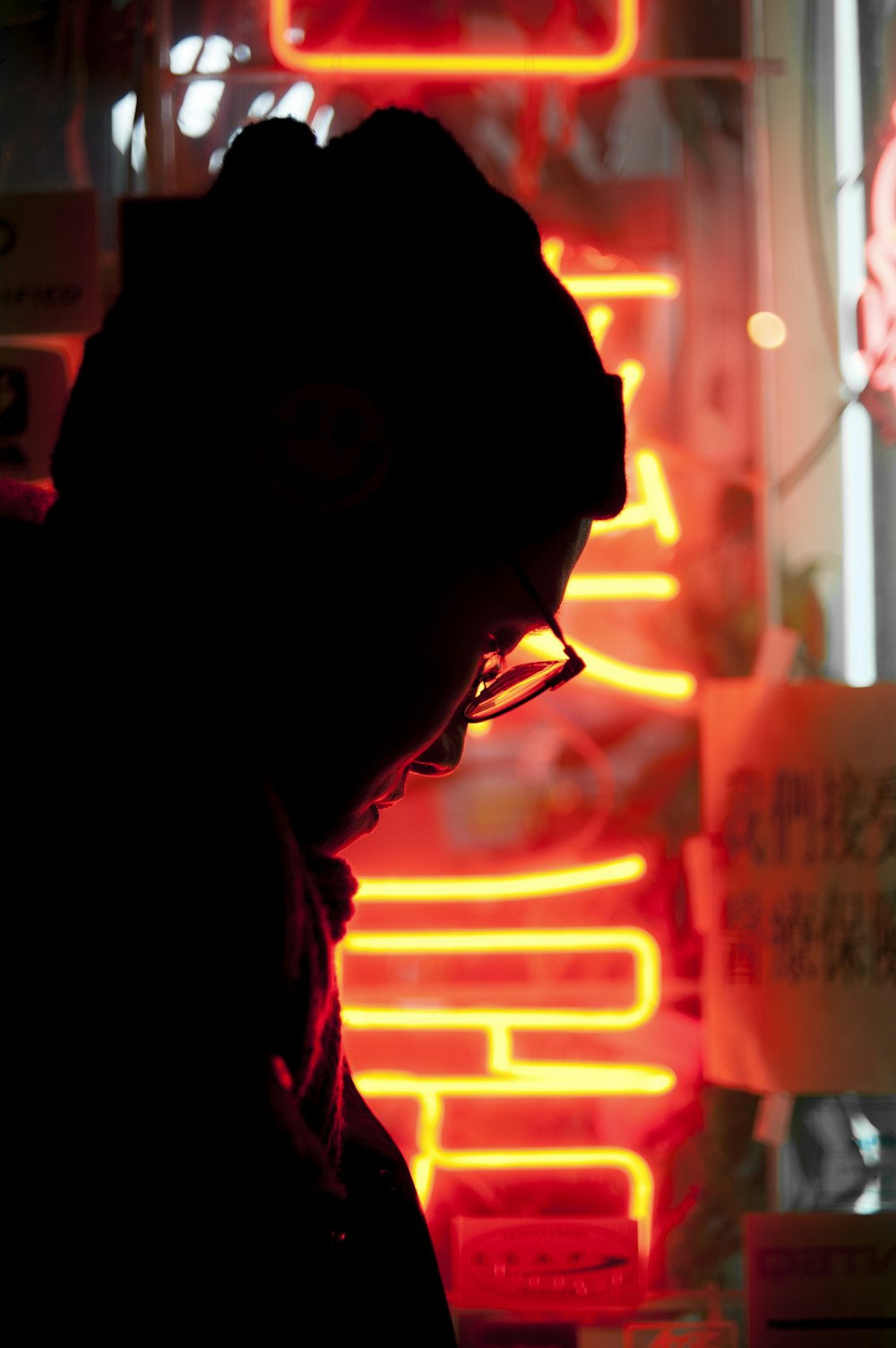 Silhouette eines Mannes in der Nähe eines gelben und roten LED-Zeichens