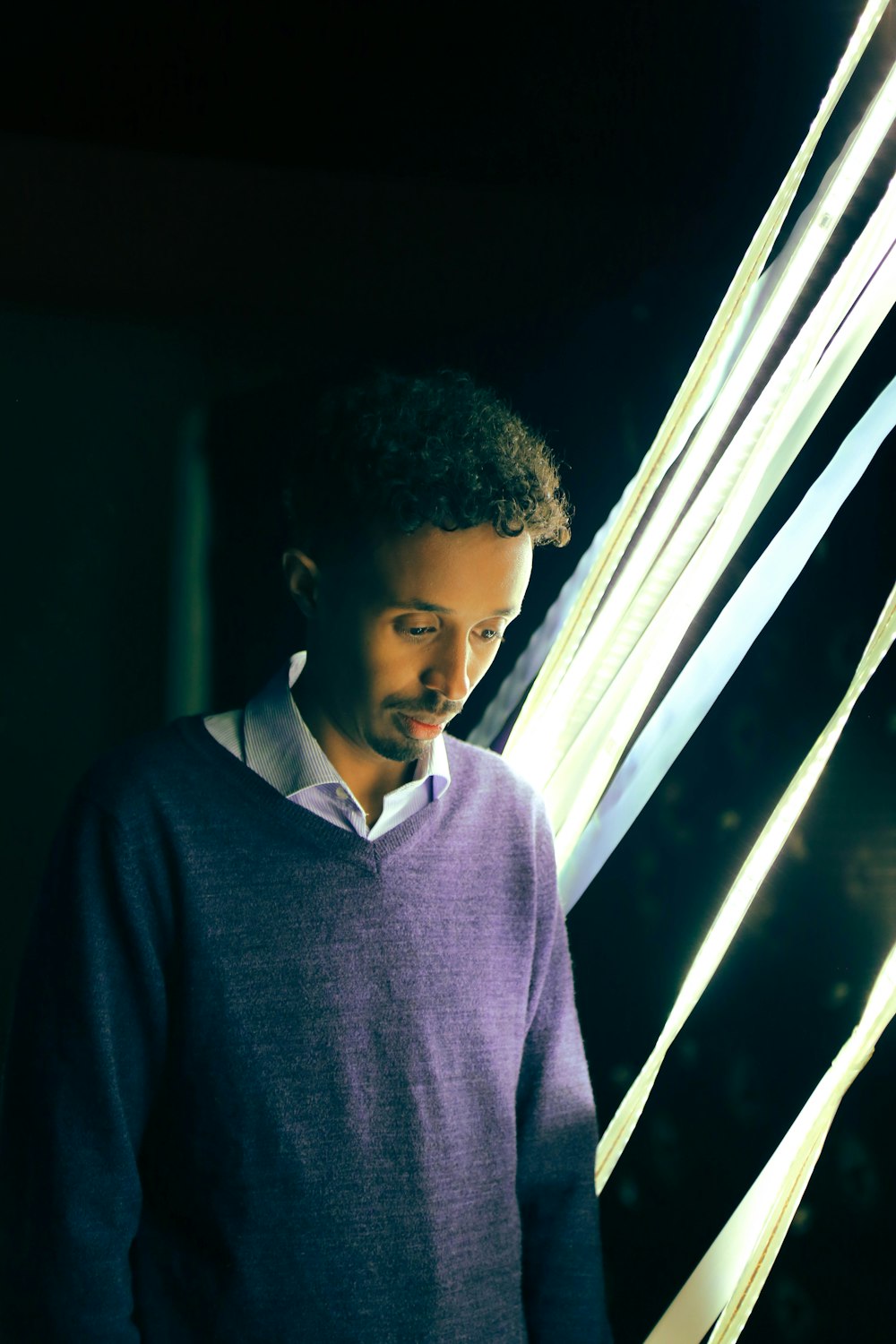 man in gray sweatshirt standing near post