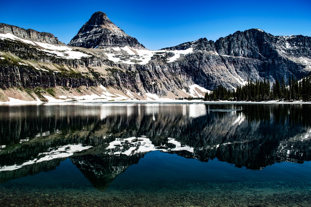 mountain covered with snow near body of water