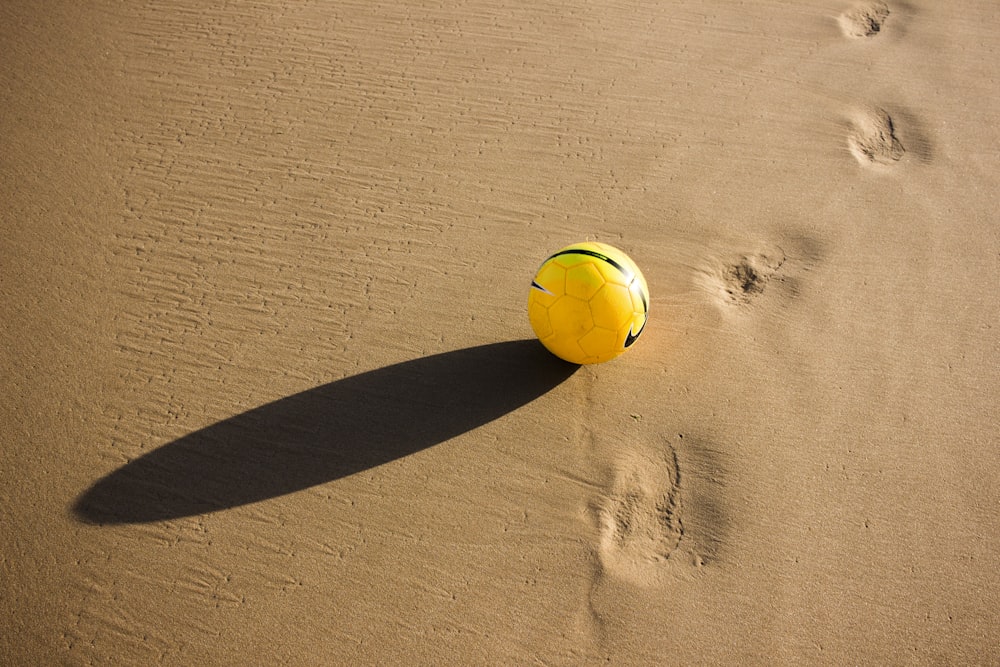 pallone da calcio giallo e verde sul deserto