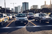 A busy city street with various taxis picking up and dropping off passengers.
