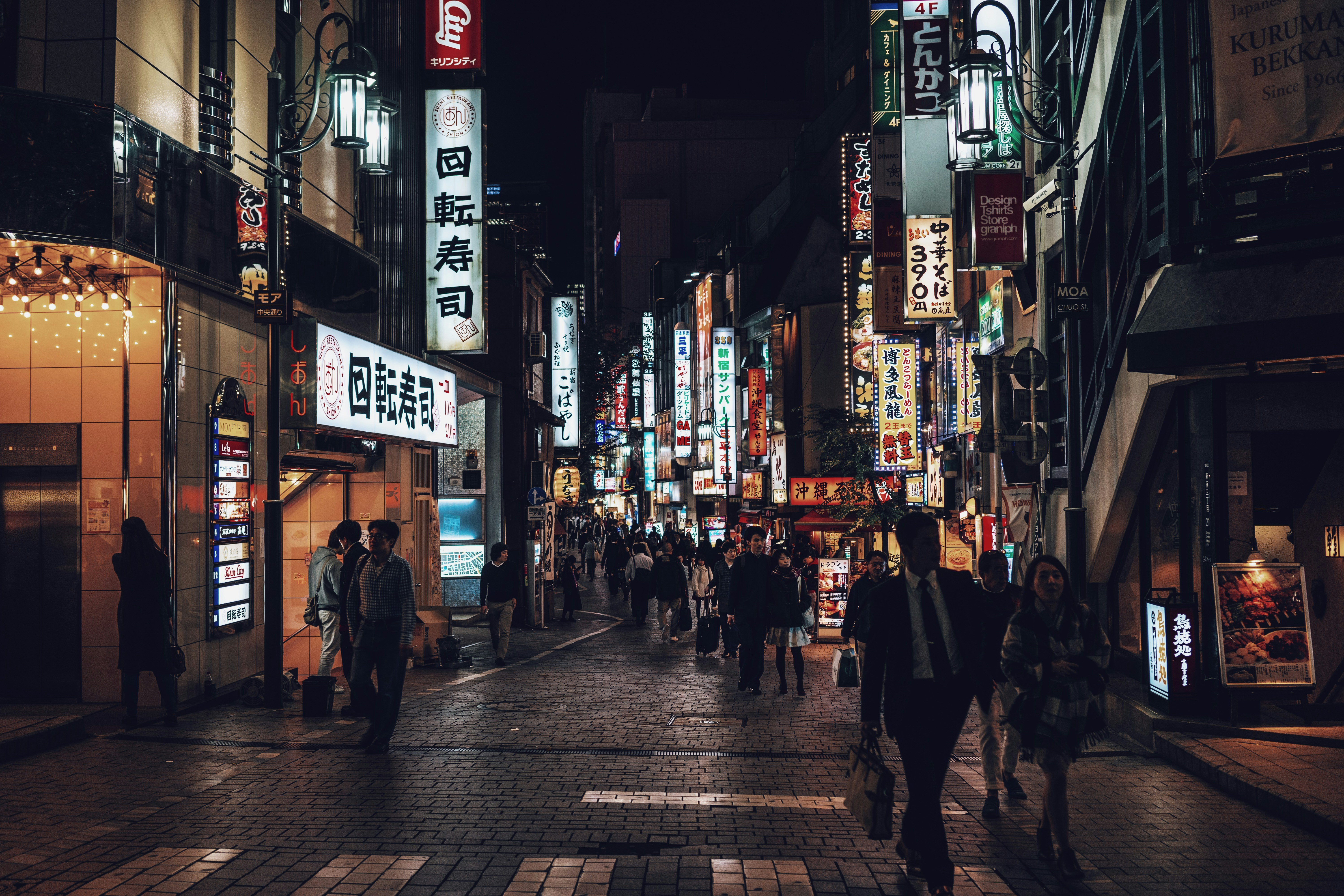 people walking beside building during nighttime, 