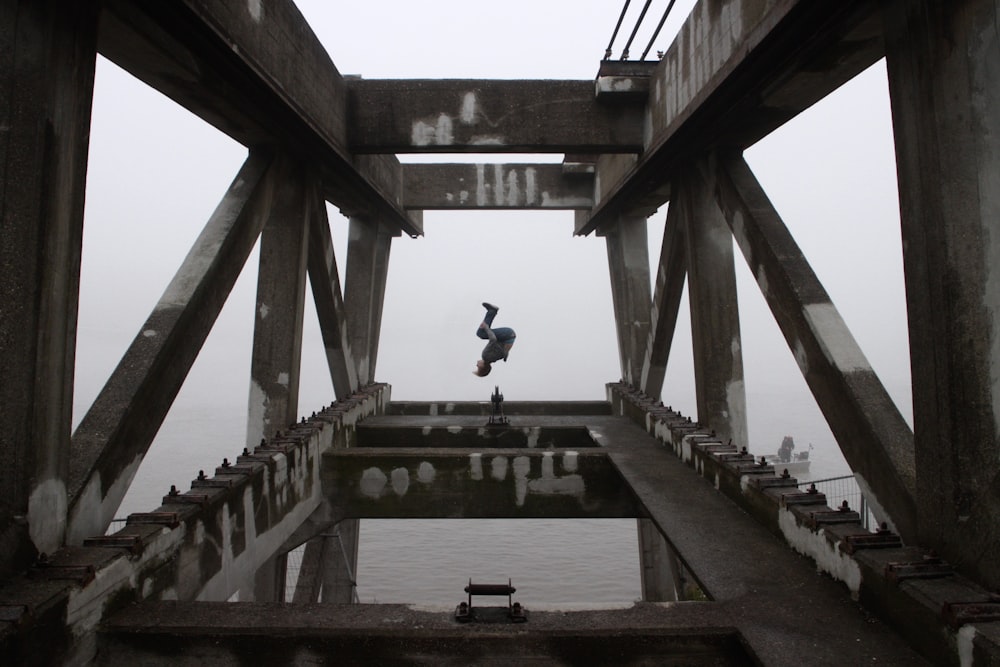 person doing back flip on building edge during daytime