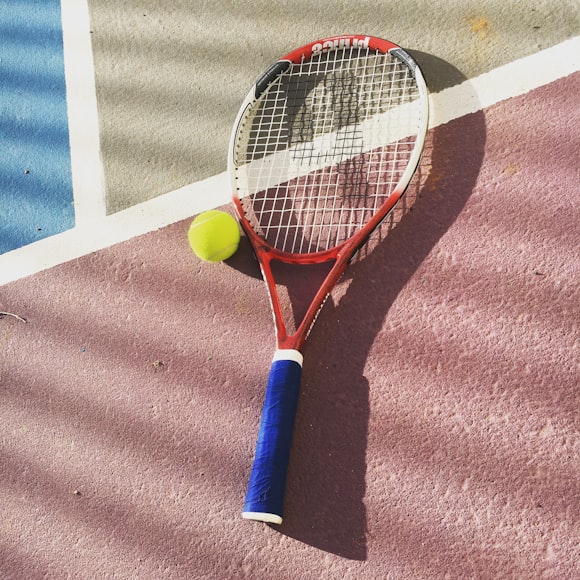 Rakieta i piłka na korcie tenisowym