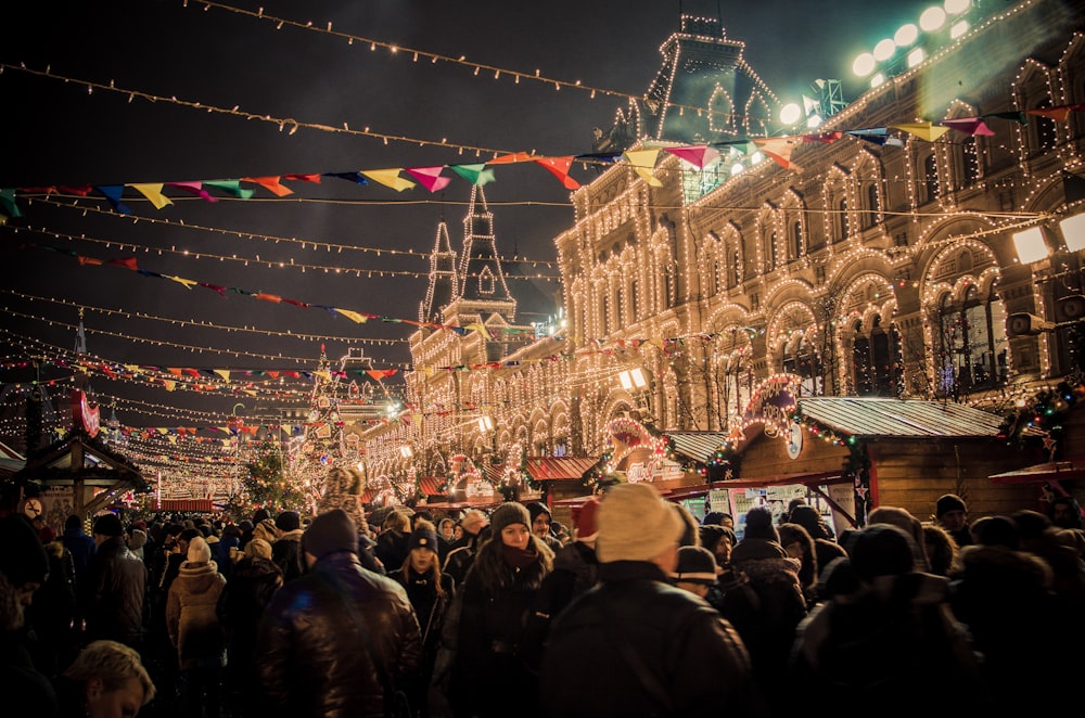 event photography of people gather outside light strings covered building