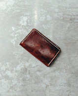 Close-up of a sleek leather wallet with visible stitching on a wooden table.