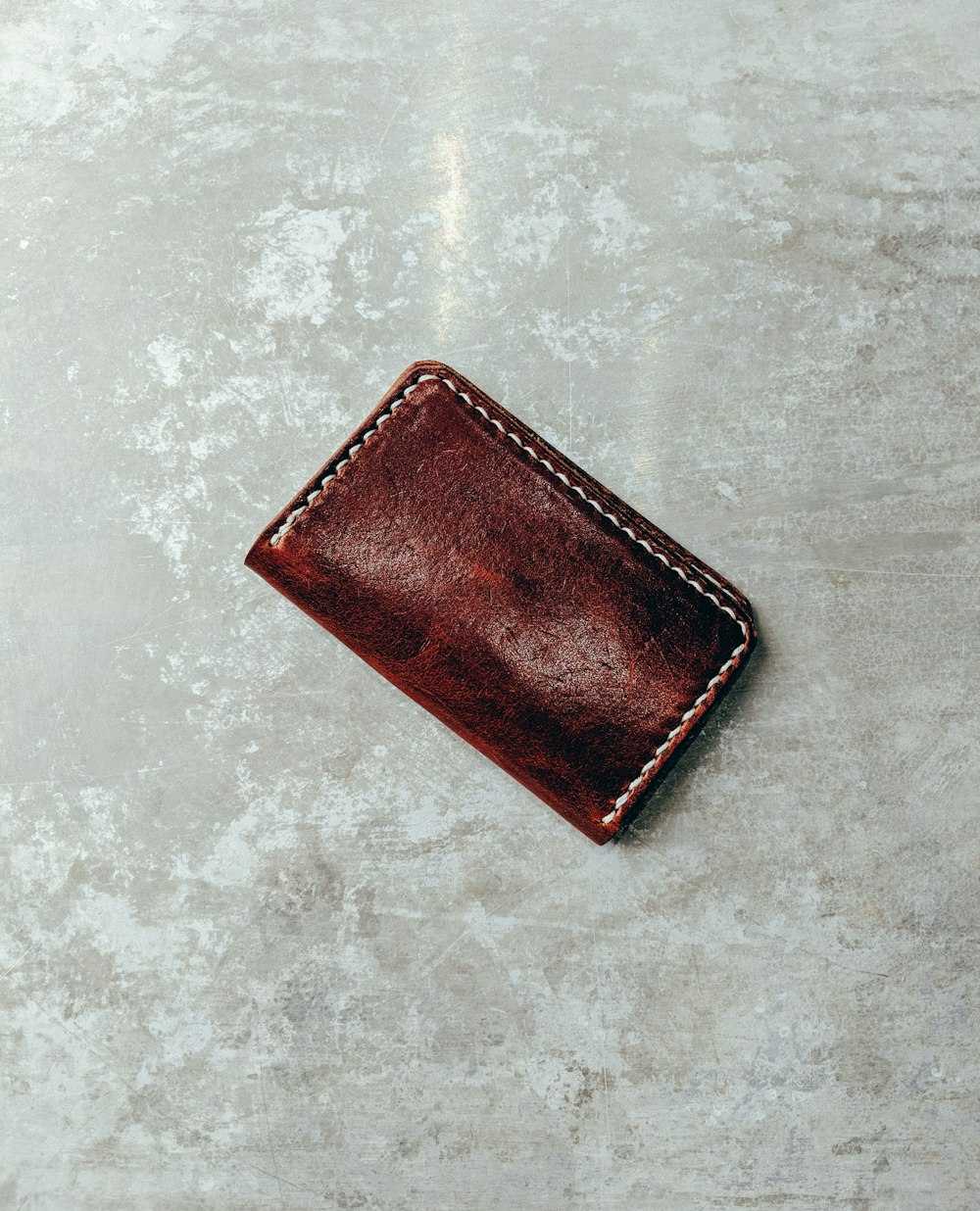 closed brown leather wallet on concrete