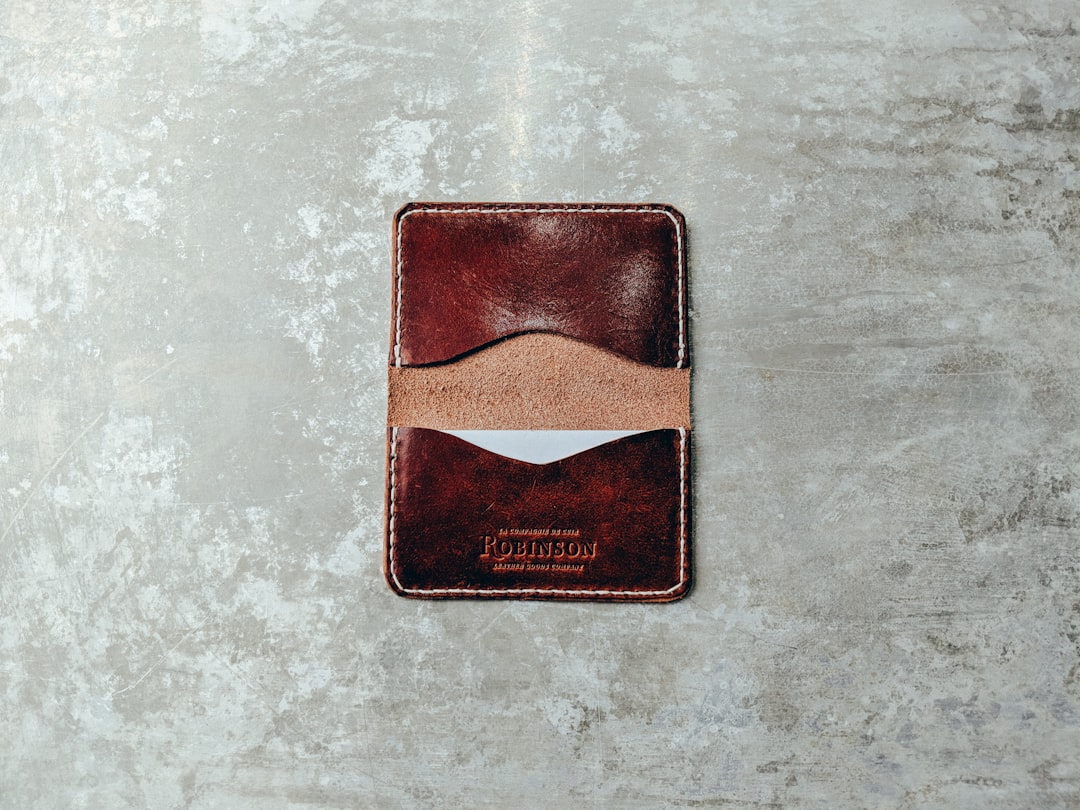 brown leather card organizer on gray pavement