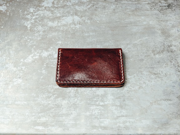 Close-up of a rich brown leather wallet showing detailed stitching.