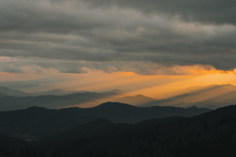 crepuscular rays shining over mountain ranges