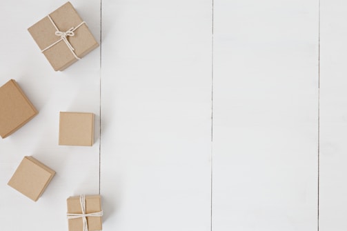 Close-up of sleek, minimalist custom paper gift boxes arranged artistically on a neutral background.