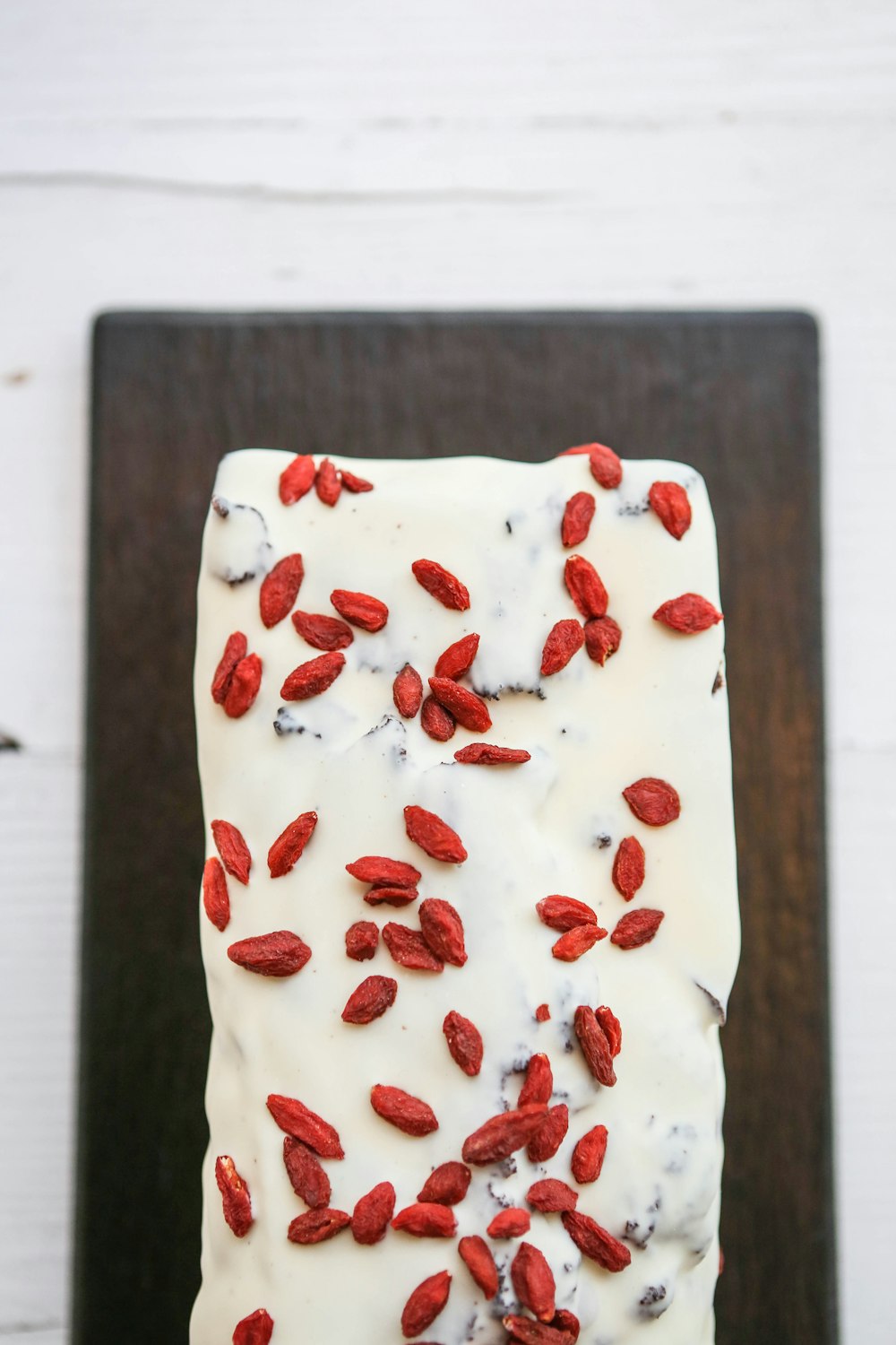 a piece of cake with white frosting and red berries on top