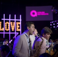 three man band playing on stage at night