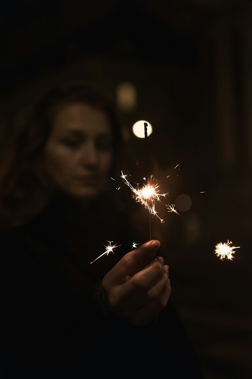 selective focus photo of woman holding firecrackers
