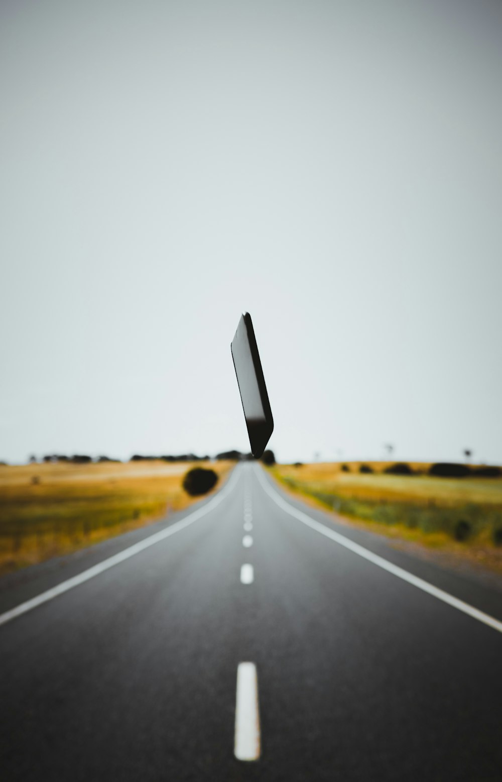 black smartphone over gray roadway