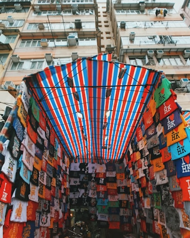 assorted T-shirts under red and blue awning
