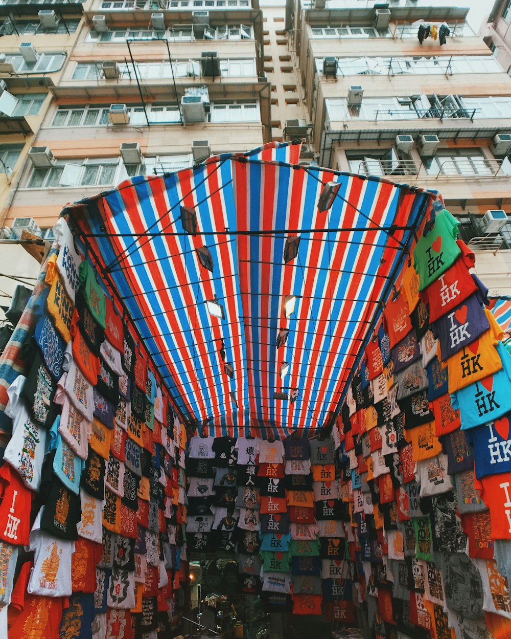 Camisetas surtidas bajo toldo rojo y azul