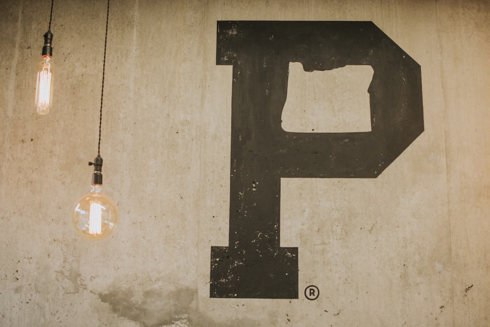 two pendant lamp near beige wall with P letter