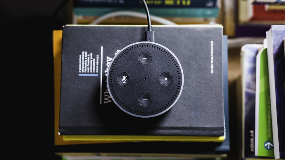schwarzes Amazon Echo auf schwarz umschriebenem Buch