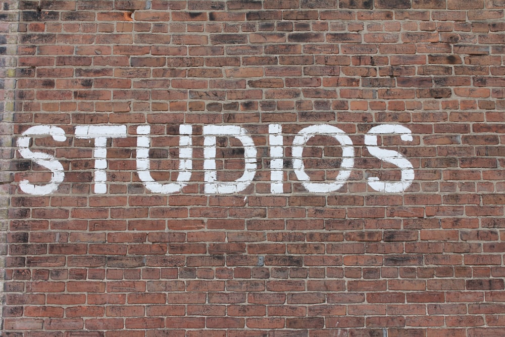 Studios text on brown brick wall