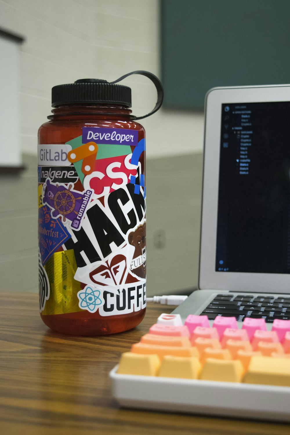 multicolored plastic bottle beside laptop