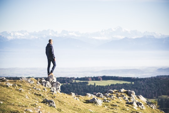 man standing on cliff in Dent de Vaulion Switzerland