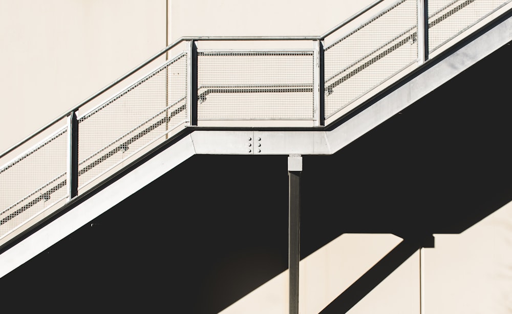 white metal stairs beside concrete wall