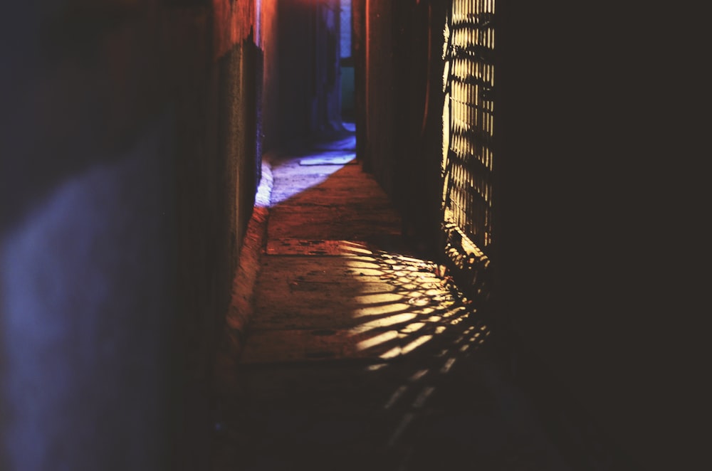 a dark hallway with a light shining on the floor