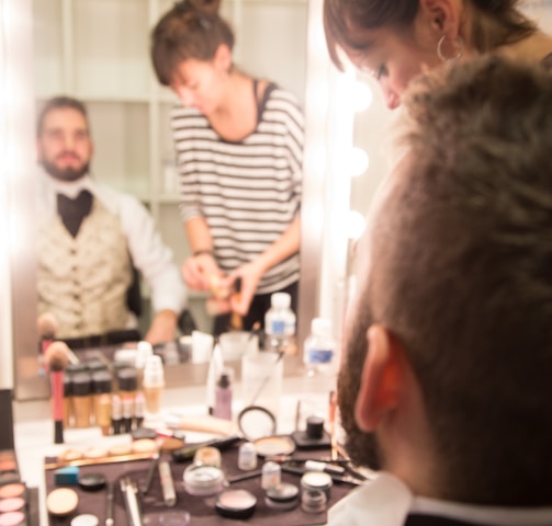 a group of people standing around a table with makeup