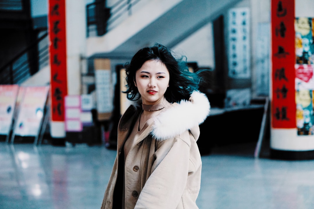 shallow focus photography of woman walking on floor tiles near staircase