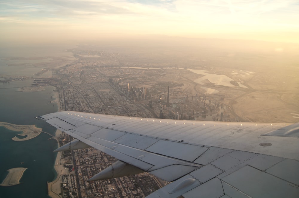 aerial view photography of airplane under city buildings during daytime