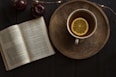 top view of open book and cup with lemon inside