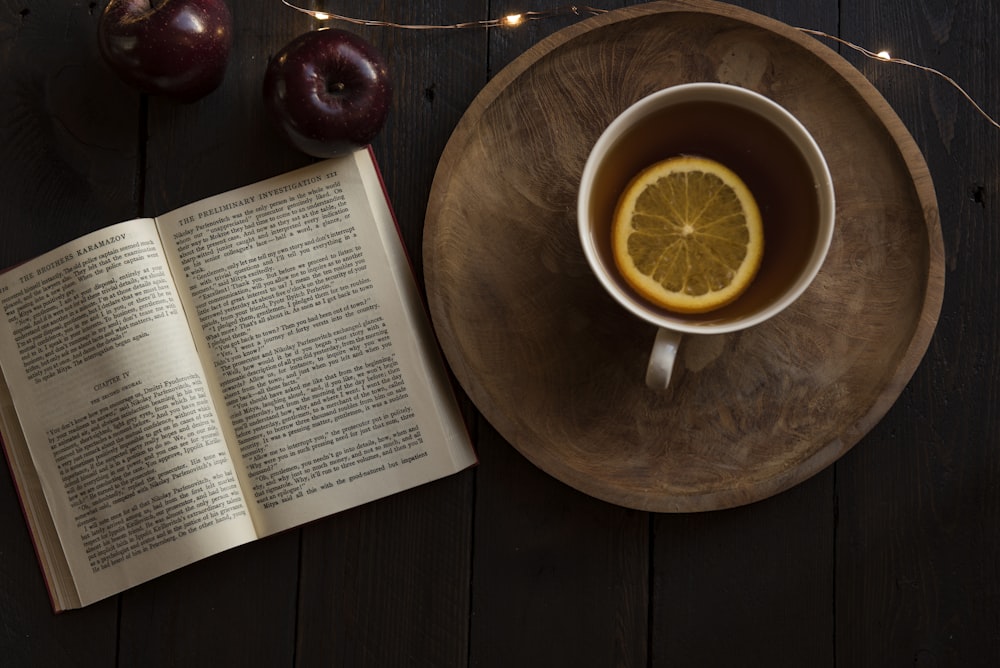 top view of open book and cup with lemon inside