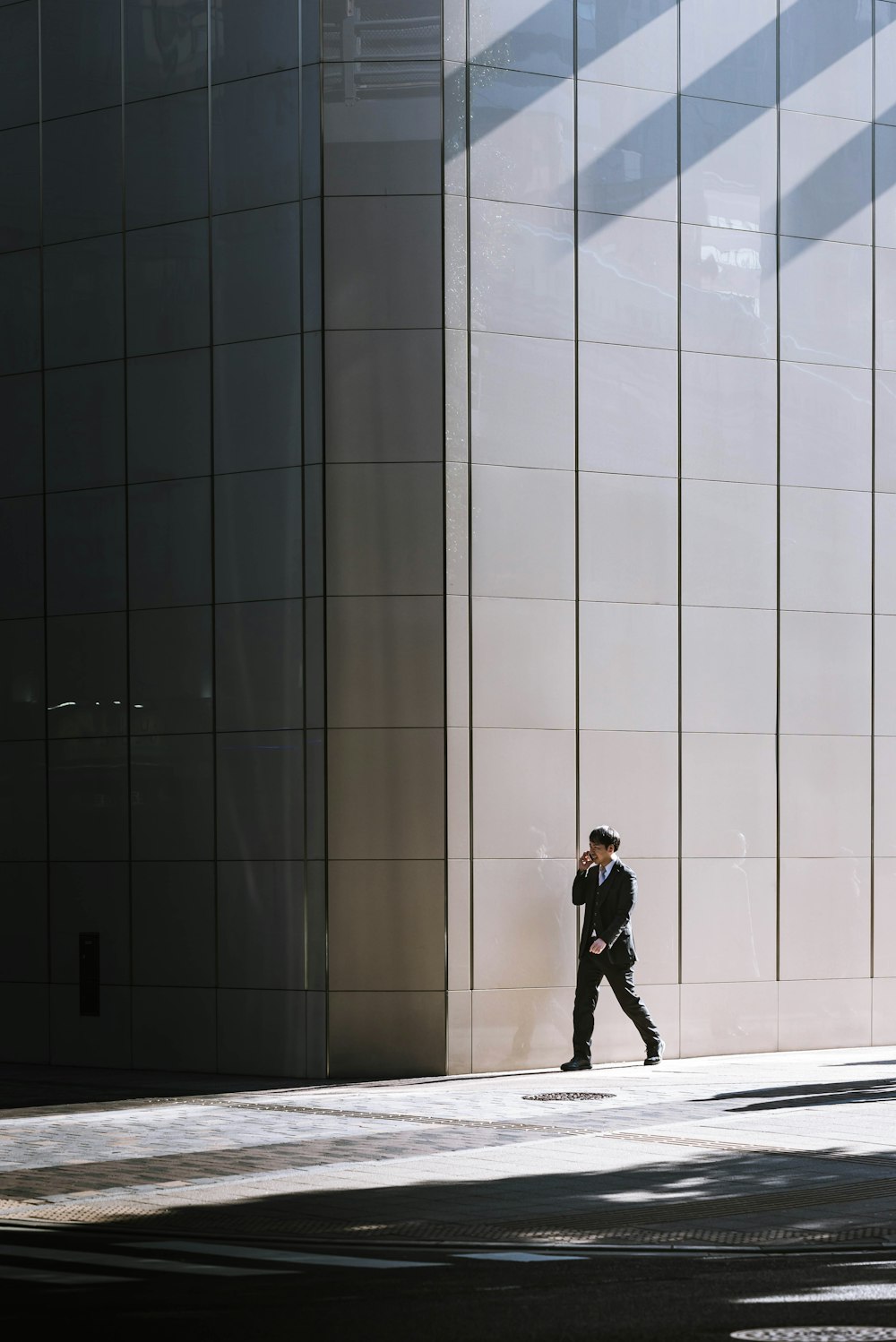 person walking beside gray building