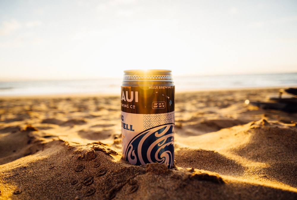 Canette de bière bleue et noire sur le rivage