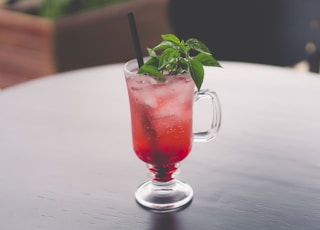 clear mug with straw and leafed plant