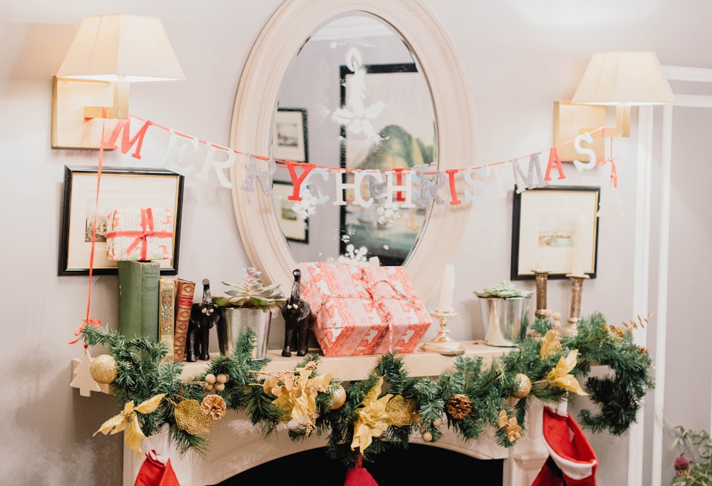 Frohe Weihnachten Briefbanner hängt an Wandleuchtern in weiß gestrichenem Raum