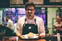 man holding fish dish on plate