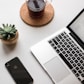 space gray iPhone X beside turned on laptop beside coffee and succulent plant