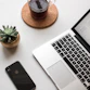 space gray iPhone X beside turned on laptop beside coffee and succulent plant