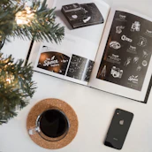 A curious person reading on a digital device surrounded by icons of planets, animals, and inventions.
