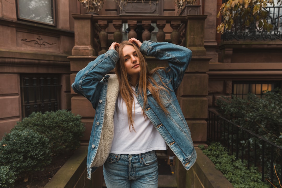 woman in blue denim jacket standing in front of hour