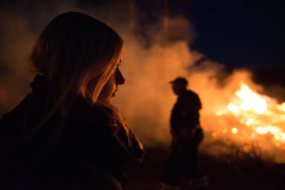 silhouette photography of man and woman nearby bush fire