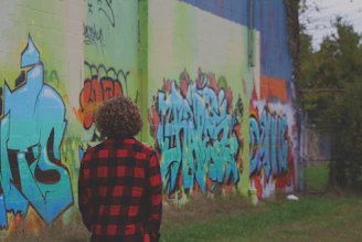 Close-up of a bold graphic streetwear shirt hanging against a graffiti wall.