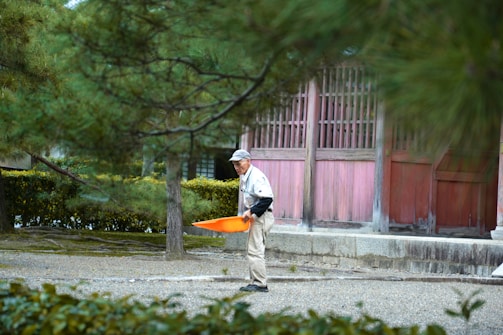 A friendly handyman holding tools standing in front of a Northern Virginia home.