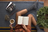 opened book on person's lap with gray socks