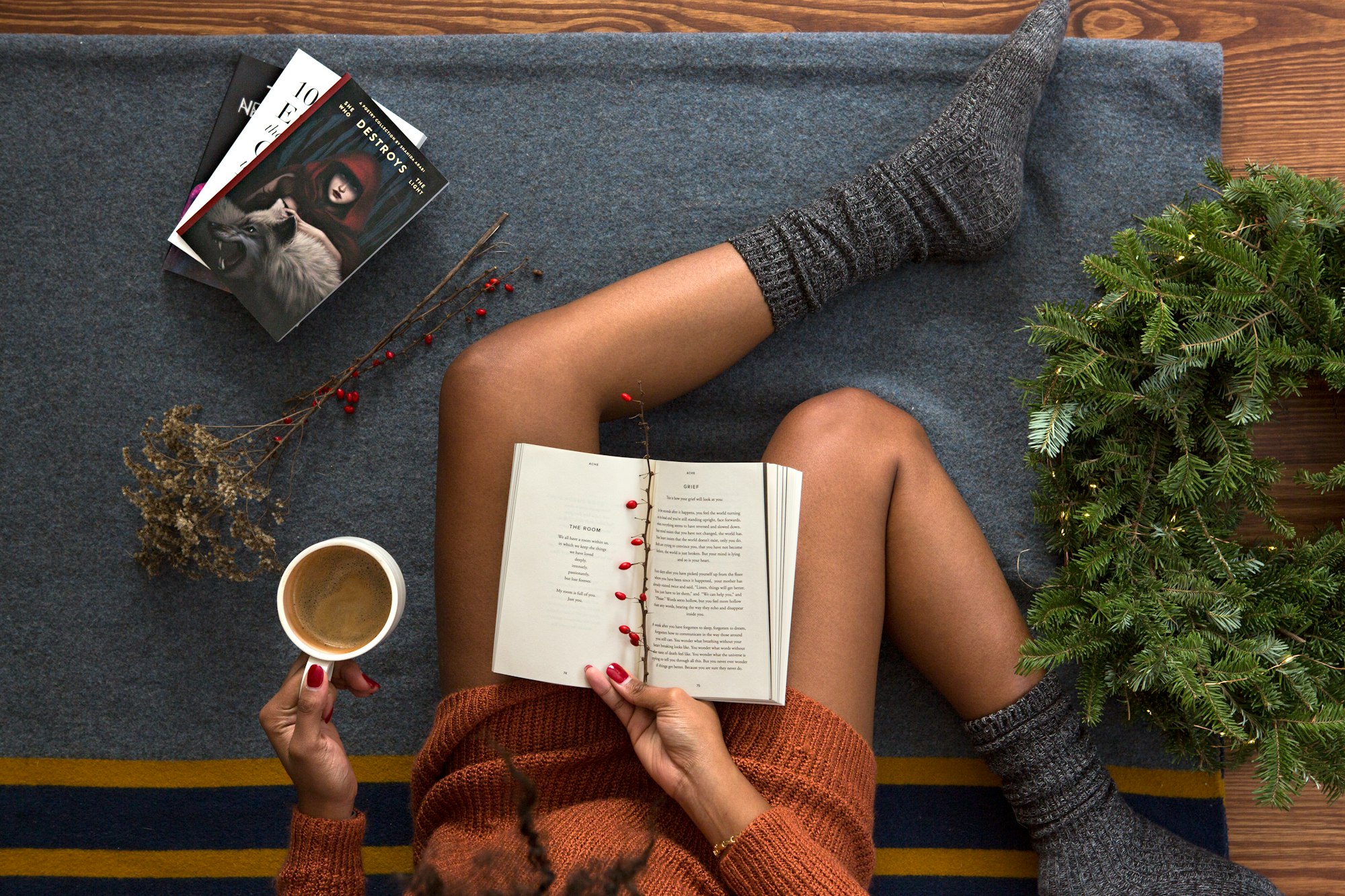 Woman reads book while drinking coffee for holiday