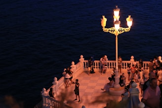 Wide shot of the two terraces with people chatting and laughing by the sea.